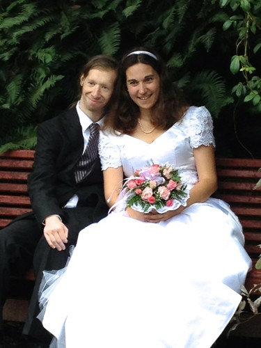 Nick And Lindsey Sitting On a Bench On Their Wedding Day